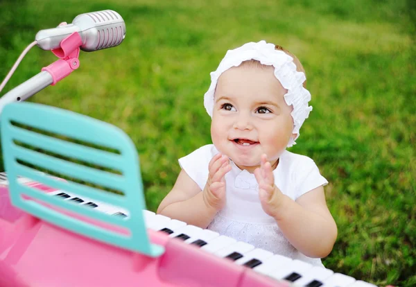 Child little girl playing on a toy piano — Stock Photo, Image