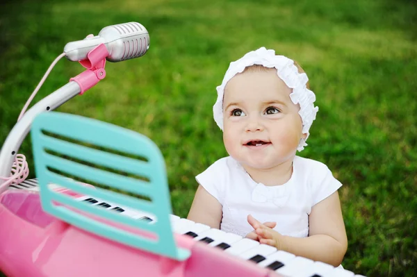 Enfant petite fille jouant sur un piano jouet — Photo