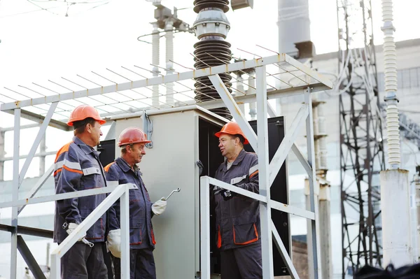 güç istasyonunda bir trafo tamir işçileri.