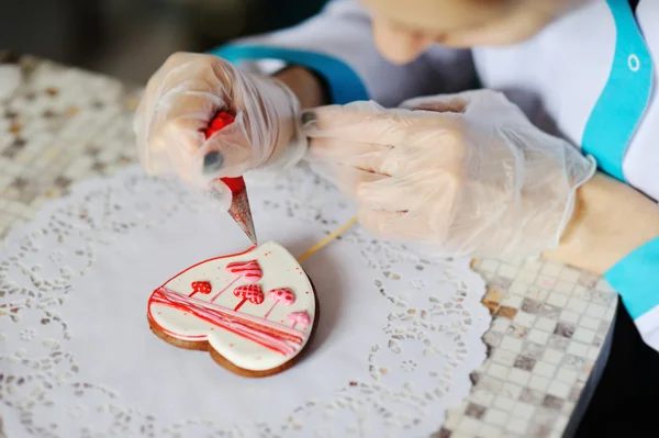 Dziewczyna ciasta zdobi Piernik serce. Valentine Walentynki — Zdjęcie stockowe