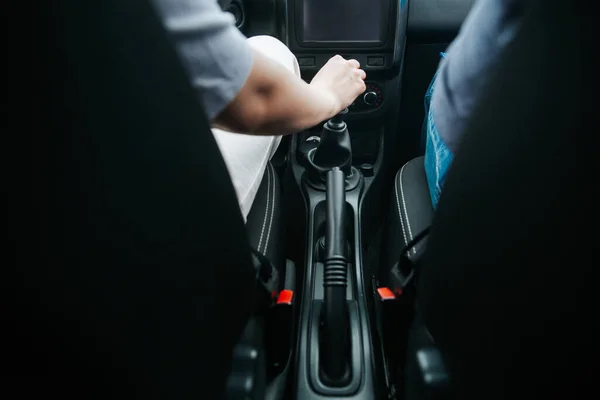 Mão masculina puxando um câmbio automático em um carro novo. Caixa de velocidades manual. Prazer em conduzir um conceito de carro. Frente borrada primeiro plano e foco na mão homem. — Fotografia de Stock