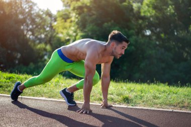 Koşu sporcusu. Erkek koşucu maraton koşusu için açık havada koşuyor. Spor formundaki genç sporcu yirmili yaşlarda. Doğa yolundaki tüm vücut uzunluğu..