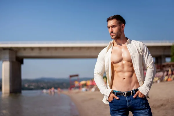ビーチで晴れた日に筋肉の男性の体のビルダーの胴 ビーチに沿って歩く筋肉の若い男性 — ストック写真