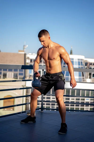 若い男はケトルベルと屋外で運動します フィットネス スポーツ 健康的なライフスタイルのコンセプト — ストック写真