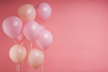 Pembe doğum günü balonları stüdyo açık pembe arka planında yüzüyor ve promosyon metni için fotokopi alanı var. Aşk, reklam afişi, sevgililer günü, düğün balayı konsepti.