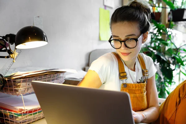 戴着眼镜的年轻女园丁使用笔记本电脑 在互联网上与顾客交流 在检疫期间在家工作 舒适的办公室 远程工作 电子学习概念 — 图库照片