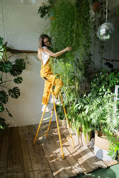 Portakal Rengi Tulumlu Neşeli Bir Kadın Bahçıvan Çiçek Dükkanında Merdiven — Stok fotoğraf