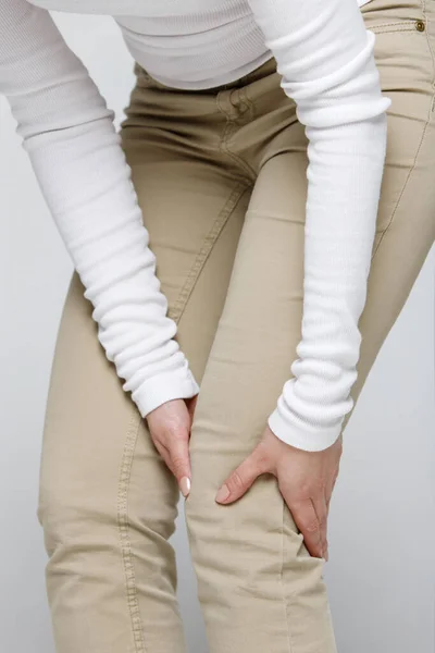 Vrouw Beige Broek Met Kniepijn Osteoartrose Geïsoleerd Grijze Achtergrond Close — Stockfoto