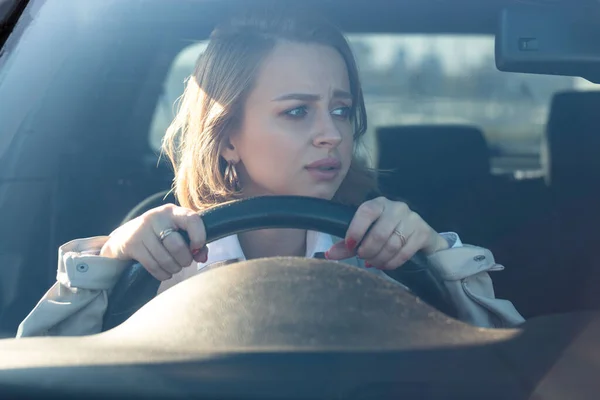 여자들은 처음으로 운전하고 자동차 사고를 피하려고 긴장하고 걱정하고 바퀴에 달라붙습니다 — 스톡 사진