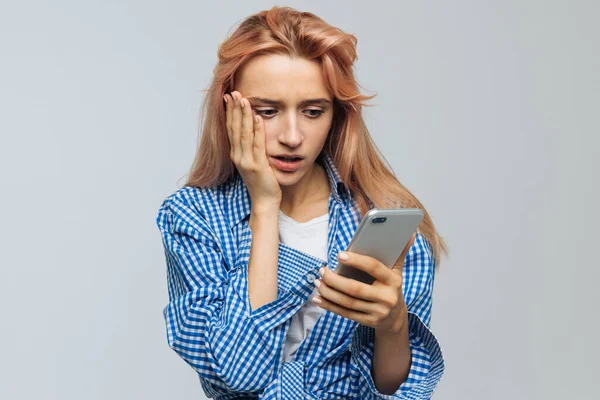 금발의 귀여운 여자가 핸드폰을 충격을 Sms News Message 배경에 고립되어 — 스톡 사진