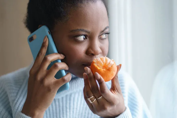 병든 여자가 전화 통화중에 신선 한 오렌지 냄새를 맡으려고 하고 있어. Covid-19 — 스톡 사진
