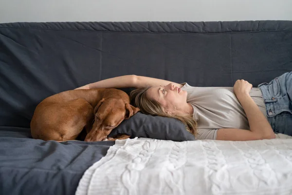 Mulher deprimida infeliz deitada com o cão em casa no sofá sente apatia tem problemas mentais. Solidão — Fotografia de Stock