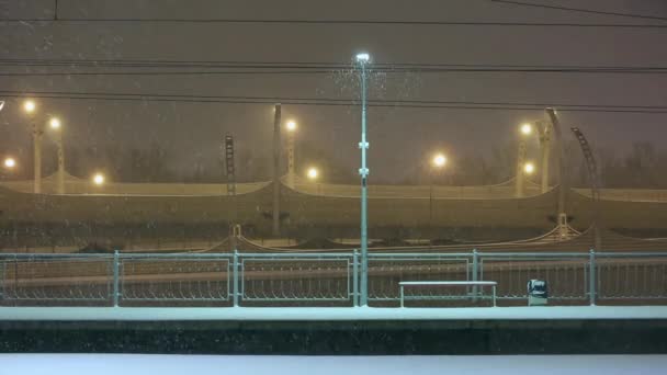 Neve estação ferroviária vazia à noite no inverno, foco em luzes de rua — Vídeo de Stock