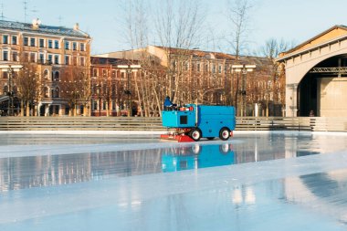 ice preparation at the rink between sessions in the sunny winter day/ Polished ice ready for match/ Ice maintenance machine in motion clipart