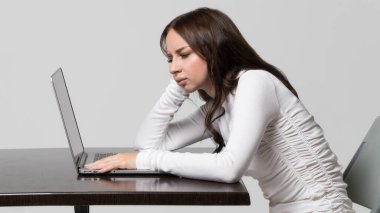 Incorrect, impaired posture position, defect scoliosis, orthopedics concept. Young woman sitting at table, looking and working at laptop, isolated. Rachiocampsis. Kyphosis curvature of the spine clipart