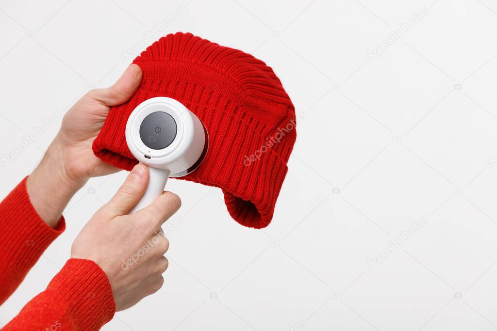 from acrylic or wool on a beanie. Electric device after cleaning and collected fluff/lint, isolated on white background with copy space. 
