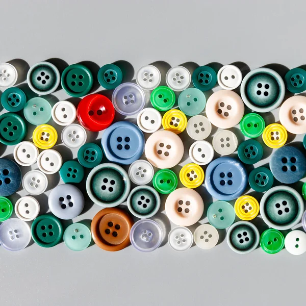 グレーの背景にカラフルな混合縫製ボタン フラットレイ 縫製品 — ストック写真
