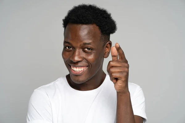 Fröhlich positiver Afro-Hipster-Mann, der breit lächelt, mit dem Finger auf dich zeigt, studiograuer Hintergrund — Stockfoto
