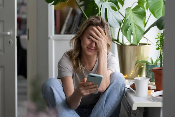 Mulher confusa fazendo gesto facepalm, olhando para o telefone celular, enviou e-mail para o endereço errado — Fotografia de Stock