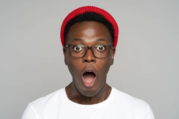 Überraschter Afro-junger Mann macht große Augen, reißt den Mund weit auf, schockiert über beispiellos niedrige Preise — Stockfoto