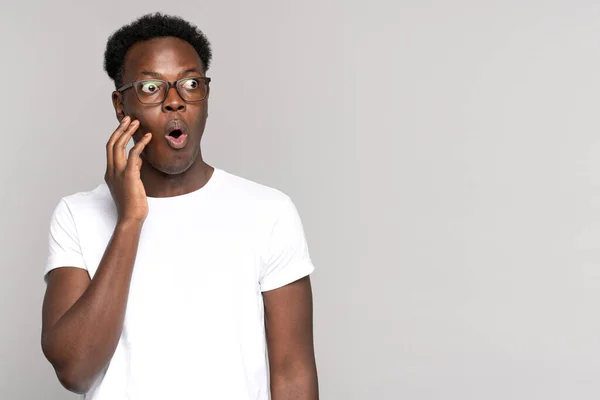 Überraschte Afro-Mann macht große Augen auf, berührt ihr Gesicht, schockiert mit beispiellos niedrigen Preisen — Stockfoto