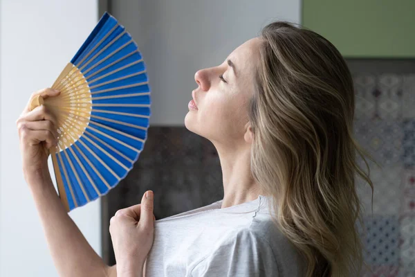 stock image Overheated woman in t-shirt using wave fan suffer from heat sweating, cools herself, feels sluggish