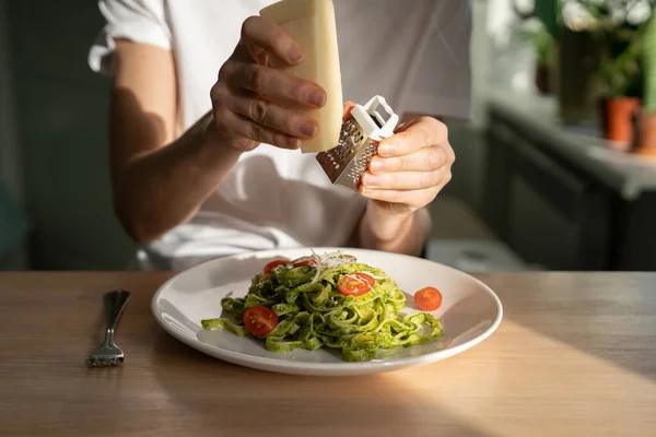 Kadın ellerinin makarna soslu ızgara parmesan peyniri ve taze vişneli domatesle yakınlaşması.. — Stok fotoğraf