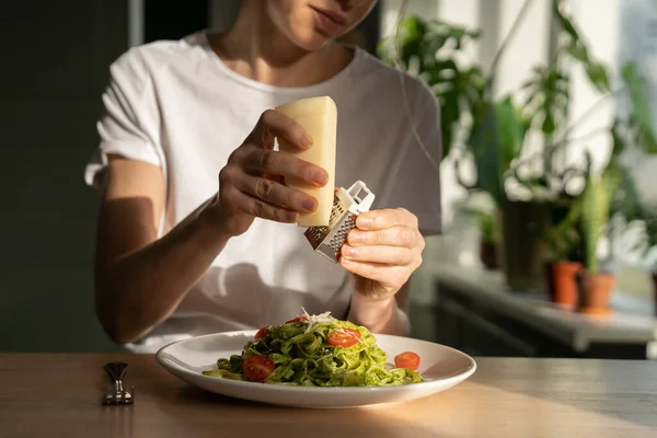 Kadın ellerinin makarna soslu ızgara parmesan peyniri ve taze vişneli domatesle yakınlaşması.. — Stok fotoğraf
