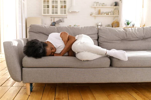 Depressive, unglückliche Schwarze Frau liegt zu Hause auf Couch, weint, leidet unter Scheidung oder Trennung. — Stockfoto