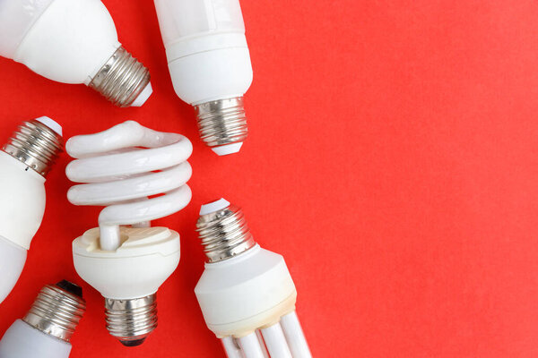 Spent incandescent halogen, cfi fluorescent, led, lumens light and energy saving bulbs tube, red background. Lamps containing mercury - extremely hazardous waste, very toxic to human health.Copy space