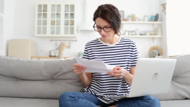 Excited young woman sit on sofa at home receiving job enjoy exam results or college admission letter — Stock Video