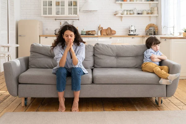 Beledigd mam en zoon zitten op de bank in woonkamer vermijden praten kijken naar elkaar na ruzie — Stockfoto