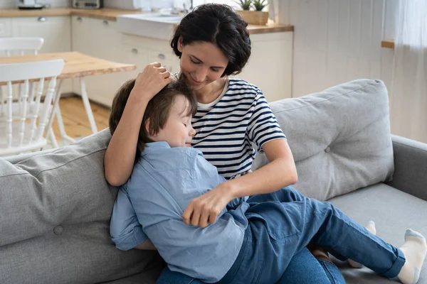 Happy mother hug son sleep on knees. Cute caucasian mom and preschool kid cuddle on couch at home — Stock Photo, Image