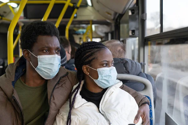 Couple in bus wearing masks while travel in new normal. African man and woman in public transport