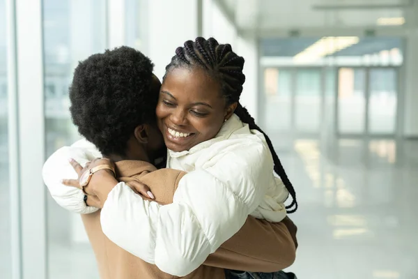 Reunião de casal no aeroporto: Africano feminino conheceu namorado abraço chegando depois de férias ou viagem ao exterior — Fotografia de Stock