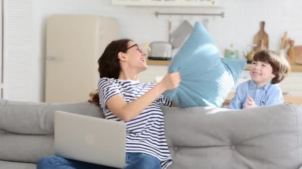 Vrolijke en vreugdevolle jonge moeder en kleine jongen lachen tijdens het spelen van grappige battle games thuis — Stockvideo