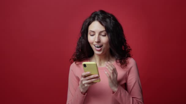 Primer plano de la joven feliz conmocionada leer el mensaje de correo electrónico en el teléfono inteligente con emoción y sorpresa — Vídeo de stock