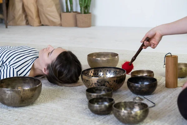 Junge Frau bei der tibetischen Massagetherapie mit Klangschalen. Wellness, Meditation und Wohlbefinden — Stockfoto