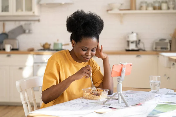 Giovane donna africana chiama amici online tramite video chat in cucina a casa durante la pausa pranzo dallo studio — Foto Stock