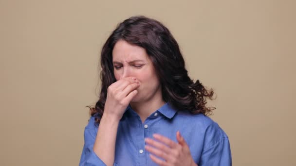 Odeur dégoûtante : la femme couvre les mains des vagues du nez pour éviter une mauvaise odeur, un arôme de pet, un gaz malodorant. Plan studio — Video