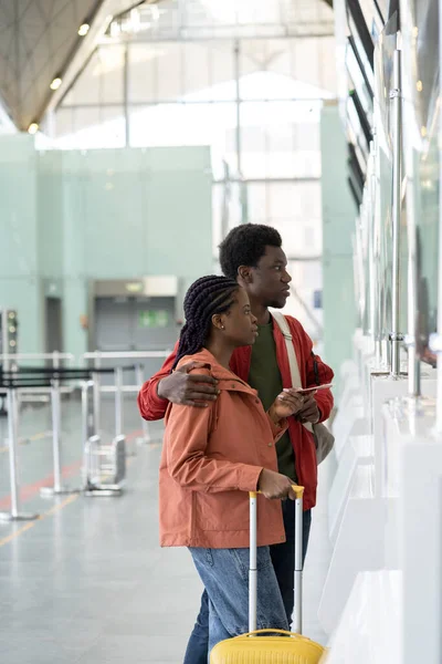 Junges afrikanisches Paar am Flughafen am Check-in-Schalter nach dem Ende der Covid-19. Erste Reise nach Coronavirus — Stockfoto