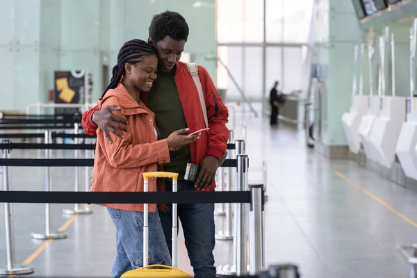 Afrikanisches Paar am Flughafen nutzt Smartphone für Online-Check-in auf dem Flug nach covid Ende. Sicheres Reisen — Stockfoto