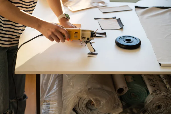 Professional tailor cut clothing design samples with cutter on table in fashion studio, closeup shot — Stock Photo, Image