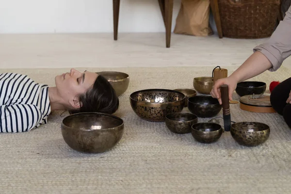 Frau übt Klangtherapie von Klangschalen zur Angsterholung und Stressabbau zu Hause — Stockfoto