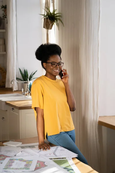 Black businesswoman talk on smartphone, architect discuss project on mobile working remotely at home — Stock Photo, Image