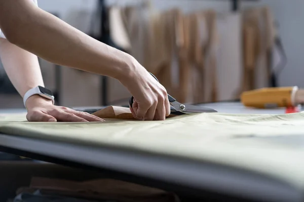 Dressmaker hand use scissors cut fabric material to sew. Closeup of work process in tailor workshop — Stock Photo, Image