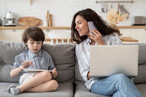 Opiekuńcza mama biznes lady porozmawiać z małym synem podczas rozmowy telefonicznej pracy na laptopie komputera w domu — Zdjęcie stockowe