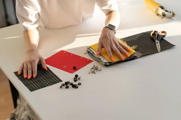 Jonge ontwerper kleermaker vrouw kiezen stalen van stof in de studio. Meisje riool kijken naar stof monsters — Stockfoto