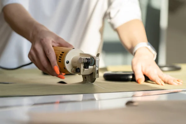 Elektrische snijplotter voor het snijden van textiel. Close-up van vrouwelijk handwerk met stof in atelier studio — Stockfoto
