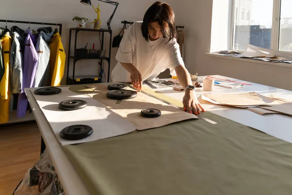 Seamstress draft paper patterns on textile with chalk and ruler. Clothes designer work in studio — Stock Photo, Image